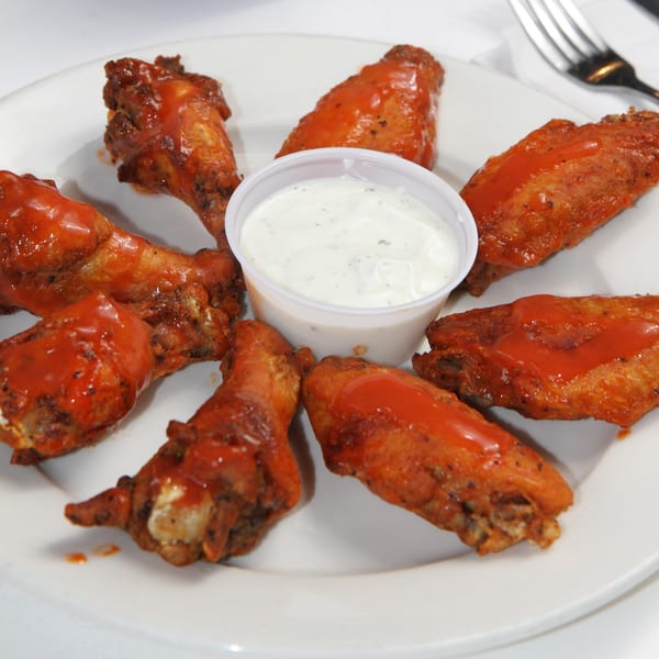 A plate of Fort Lee Pizzeria's buffalo wings with a side of ranch dressing.